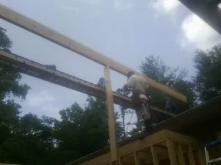 Carpenter setting a ridge beam over a new addition frame — Ice Dam Removal by Roofing Brothers in Barnett