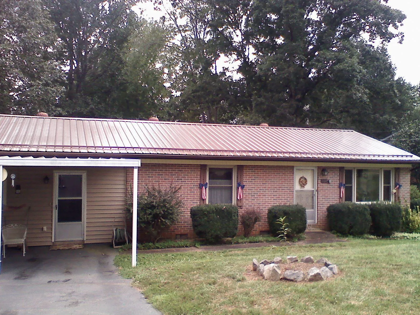 Bronze metal roof and carport on a brick ranch home — Roof Repair work by our crew in Barnett